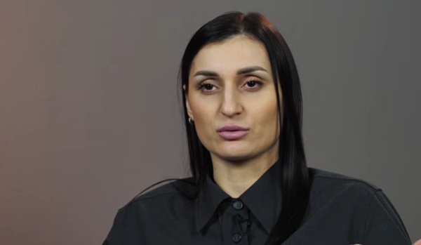 femeie bruneta cu parul desprins drept imbracata in camasa neaga