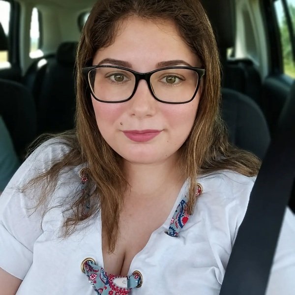 selfie facut de femeie cu parul lung si camasa alba la volan