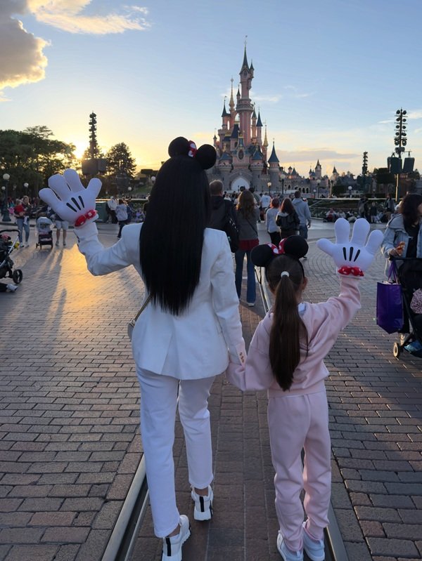 adelina pestritu in costum alb cu pantaloni si funda de minnie mouse in par alaturi de fiica ei