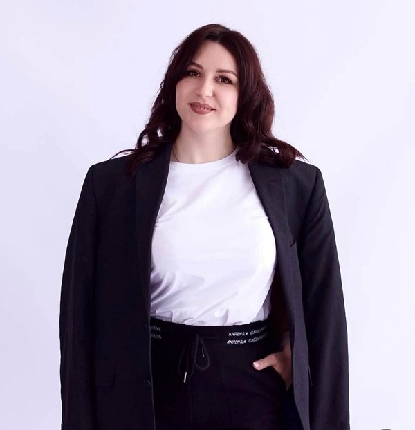 femeie in maleta alba imbracata in costum negru