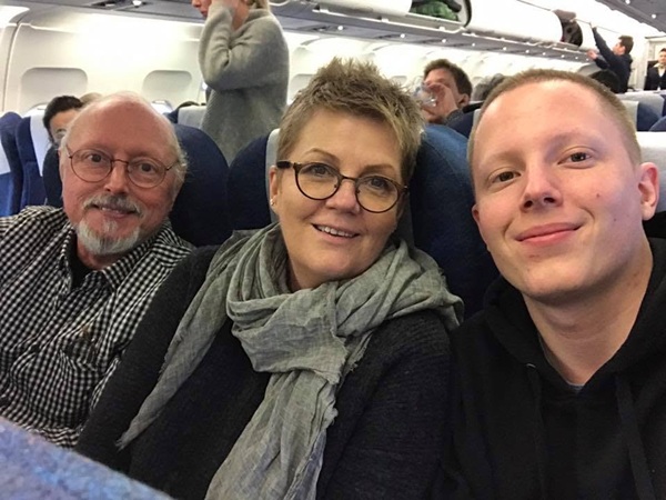 crina mardare in negru cu esarfa gri la gat alaturi de fiul si sotul ei in avion