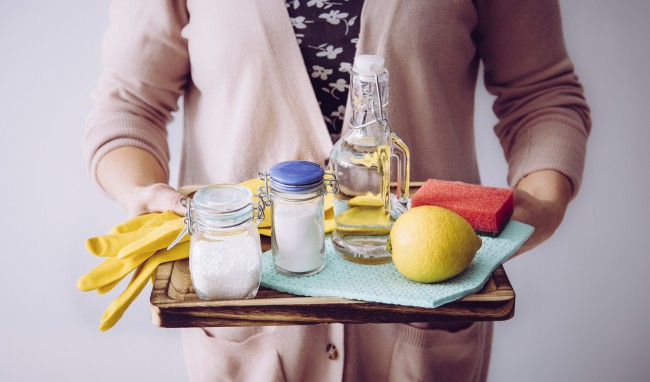 Femeie care tine o tava cu ingrediente pentru detergent facut in casa