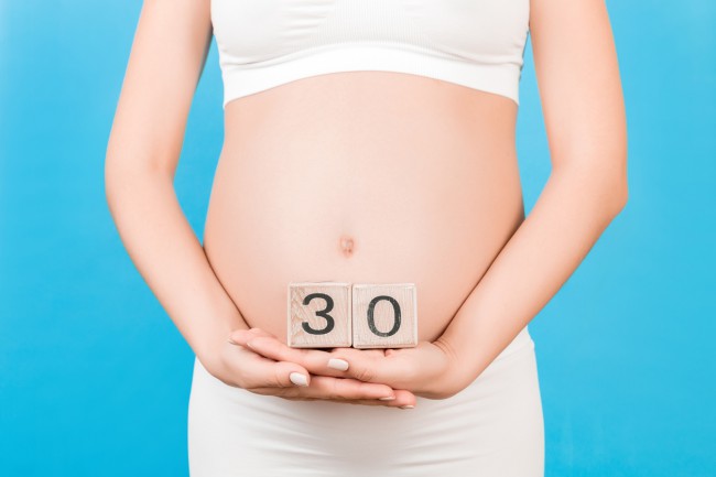 femeie-gravida-care-tine-in-maini-in-dreptul-burtii-doua-cuburi-pe-care-scrie-30