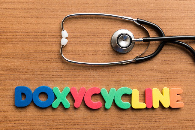litere-colorate-care-formeaza-cuvantul-doxicilina-si-un-stetoscop-ambele-asezate-pe-o-masa