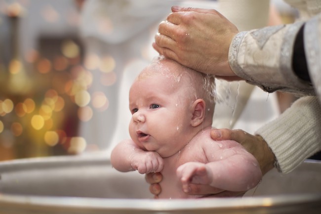 bebelus-care-este-botezat-in-cristelnita