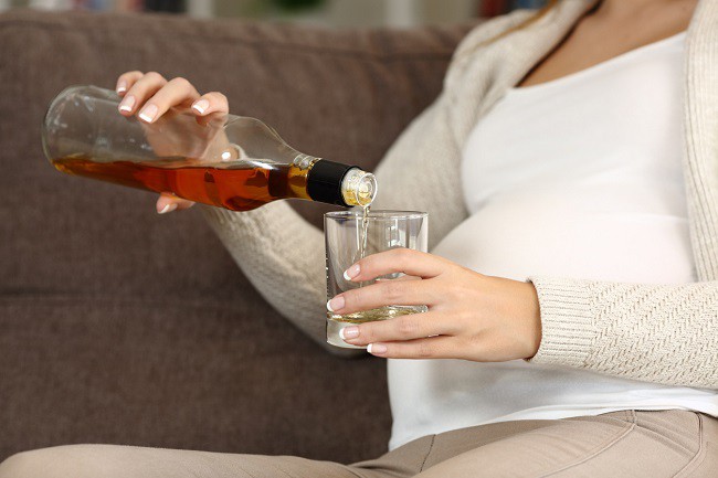 femeie-gravida-care-toarna-bautura-alcoolica-intr-un-pahar