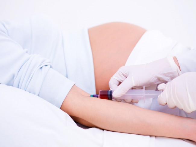 femeie-gravidă-care-stă-întisă-pe-un-pat-și-i-se-recoltează-sânge