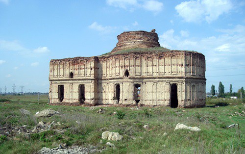 manastirea-chiajna-poza-din-exterior-unde-se-vede-ca-manastirea-se-afla-pe-un-camp-verde