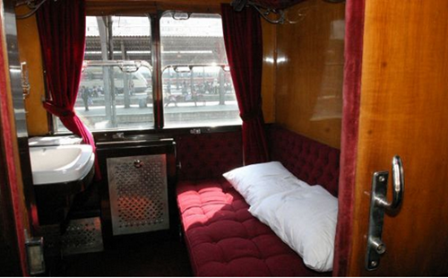 trenul-regal-vagon-de-dormit-cu-pat-rosu-pe-care-se-afla-perne-albe-chiuveta-alba-si-perdea-rosie