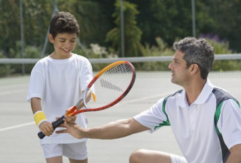 Baiat invata sa joace tenis