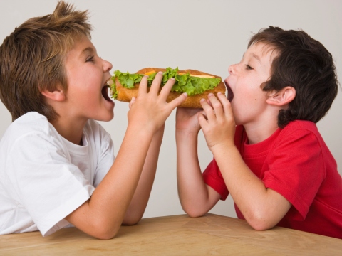 Copii mancand un sandvis