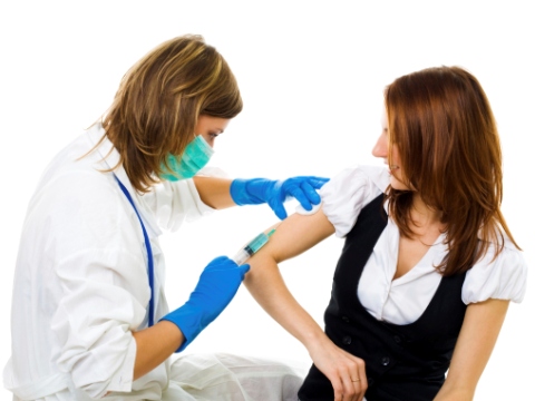 Asistenta administreaza vaccin unei femei